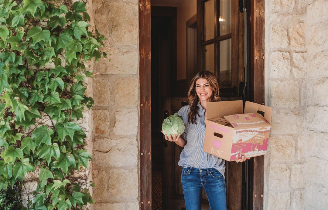 Gen holding a box of organic food from Imperfect Produce